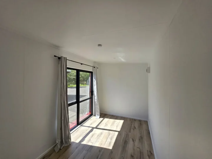 Long view of a cabin interior with sun across the vinyl plank floor