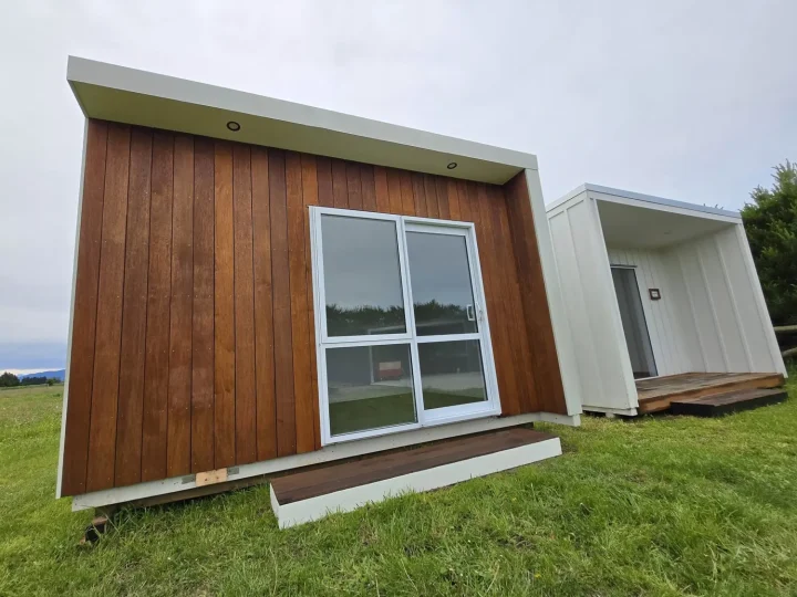 Cabin with a kwila front, white sides and a white-framed sliding door