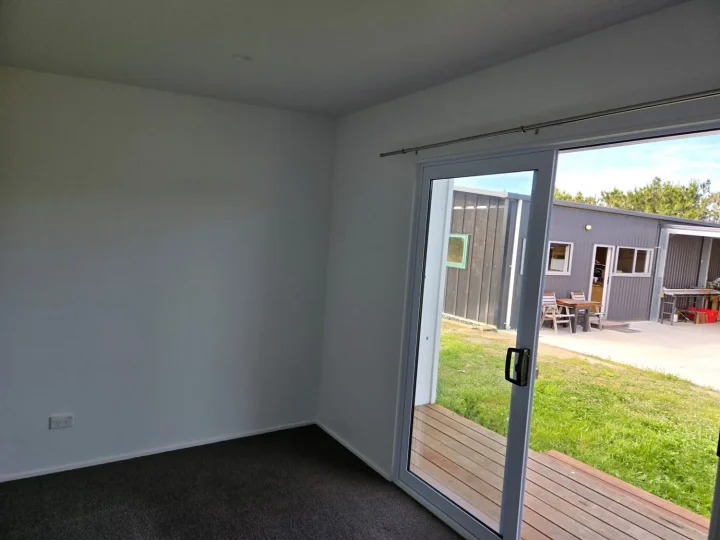 Carpeted cabin interior with the sliding door open onto the deck