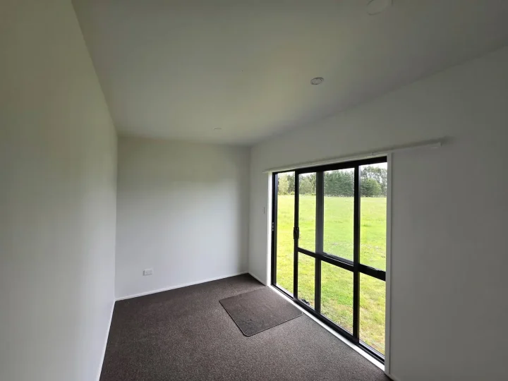 Carpeted cabin interior with a black-framed window looking onto a paddock