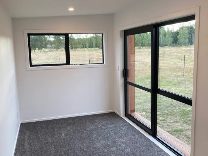 Carpeted cabin interior with a high window and a glazed door