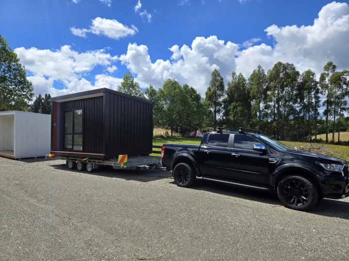 A cabin on a trailer hitched to the ute, ready to leave the yard