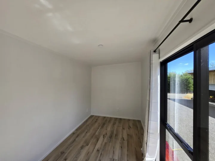 Cabin interior with vinyl plank flooring and a curtain at the sliding door
